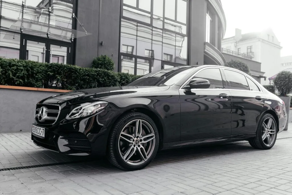 Elegant black Mercedes car parked on city street, showcasing luxury design.